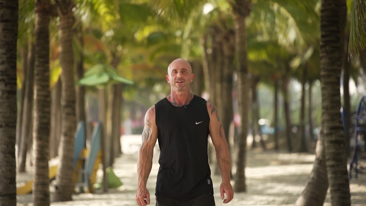 Ian walking along the palm-lined Da Nang beachfront
